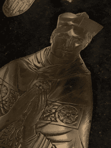 Polished brass tomb covering.